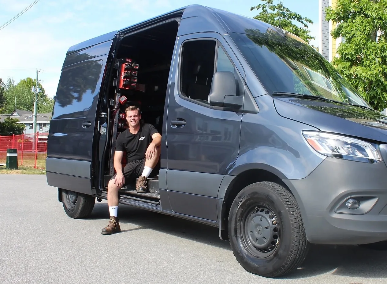 Skylar Allan in the side door of his Straight Flush Plumbing van